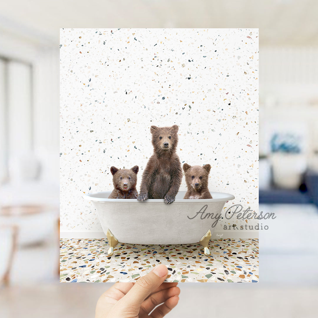 a hand holding a card with three bears in a bathtub