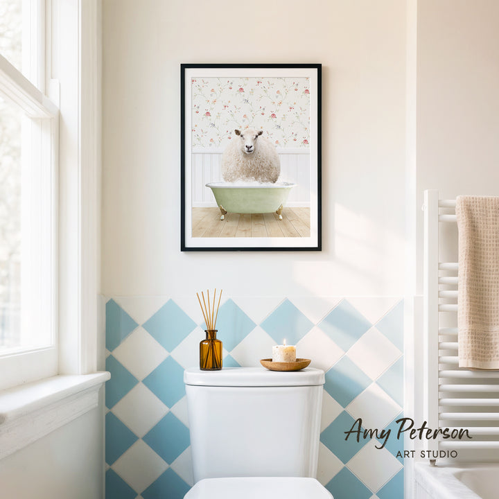 a bathroom with a framed picture of a sheep in a bathtub hanging on the wall above a white toilet.
