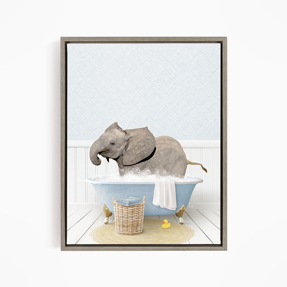 A gray elephant is sitting in a blue bathtub filled with water, surrounded by a yellow rubber duck and a basket.