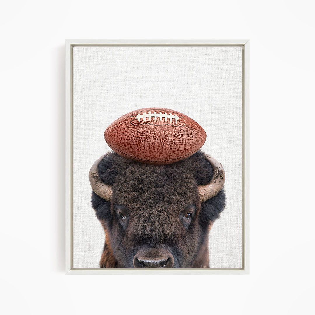 A buffalo with a football resting on its head.