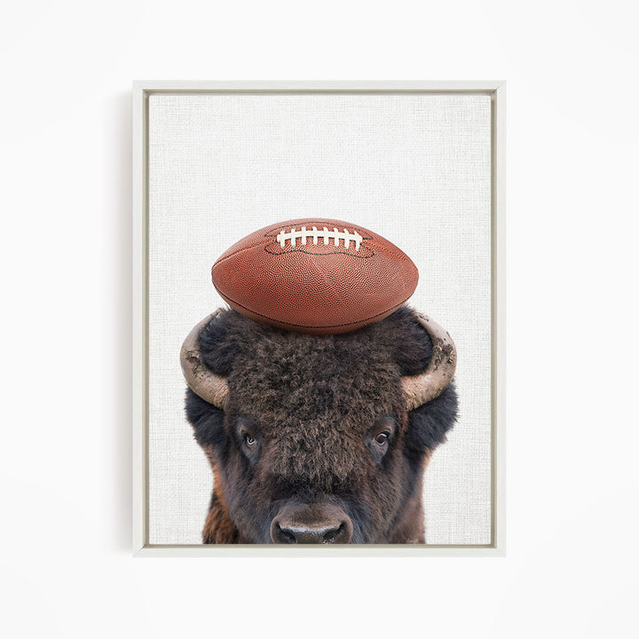 A buffalo with a football resting on its head.