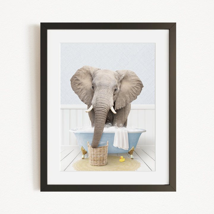 A gray elephant is standing in a blue bathtub, surrounded by yellow rubber ducks.