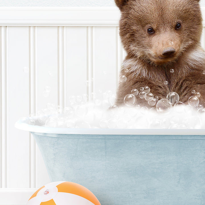 a brown bear sitting in a bath tub filled with bubbles