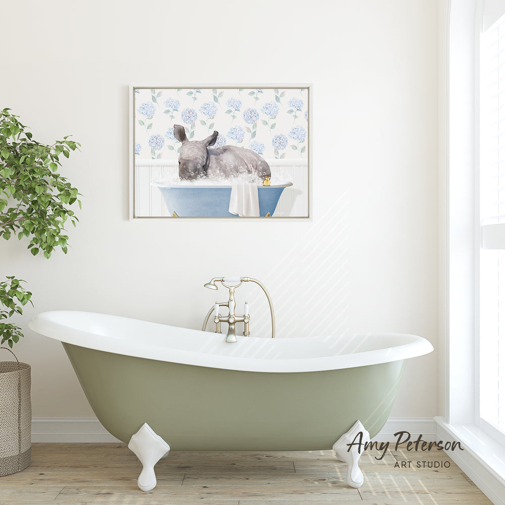 A green clawfoot bathtub with a white interior sits in a bathroom, with a framed painting of a rabbit in a blue bathtub hanging on the wall above it.
