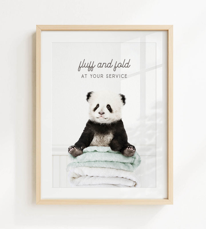 A panda bear sitting on a stack of towels with the text "fluffy and folded at your service" written above it.