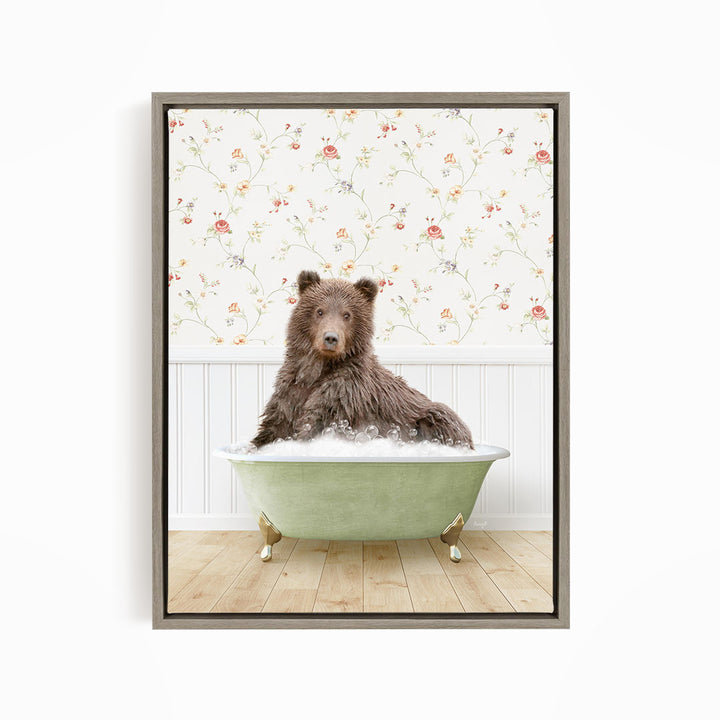 A brown bear sitting in a green bathtub filled with bubbles, with a floral wallpaper in the background.