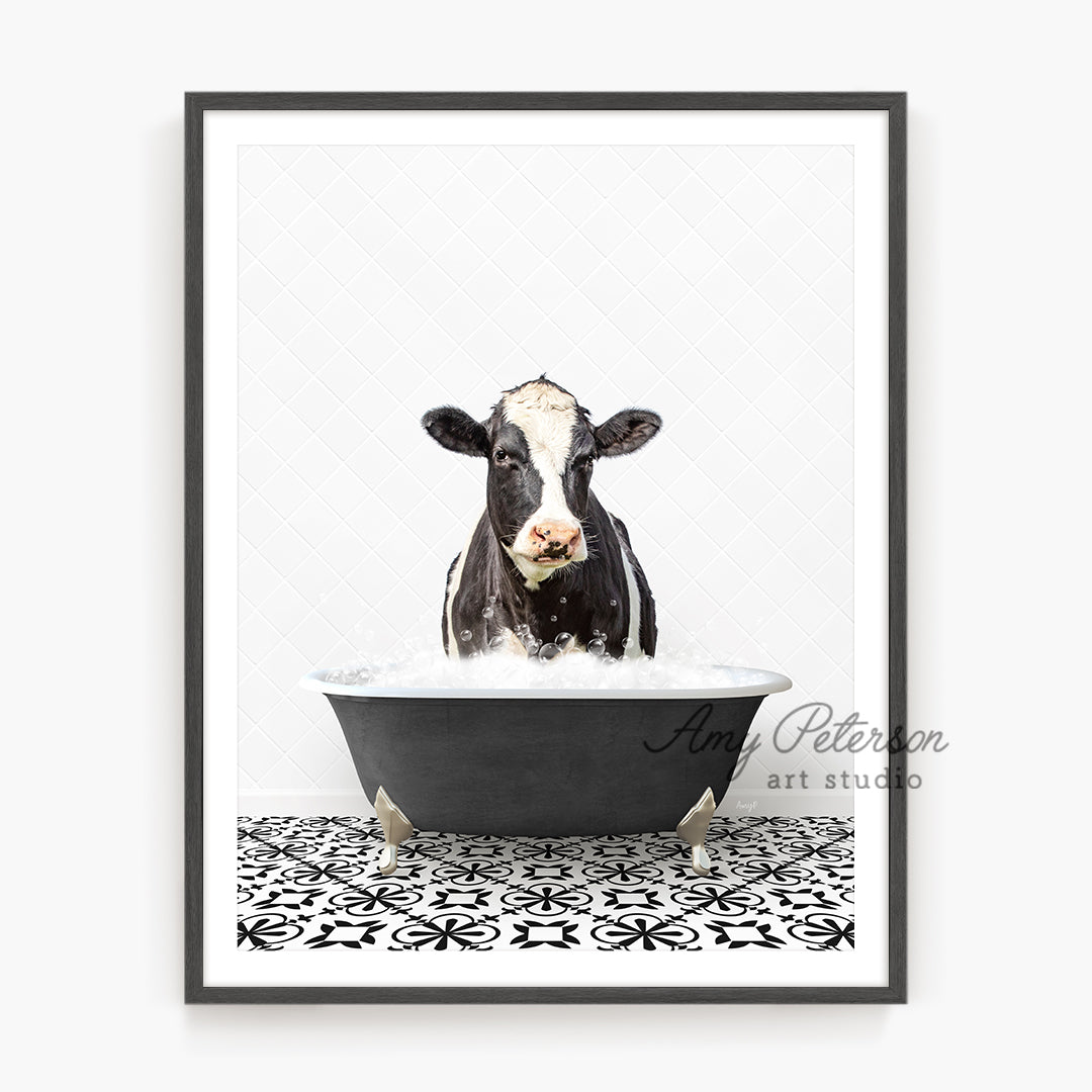 a black and white cow sitting in a bathtub