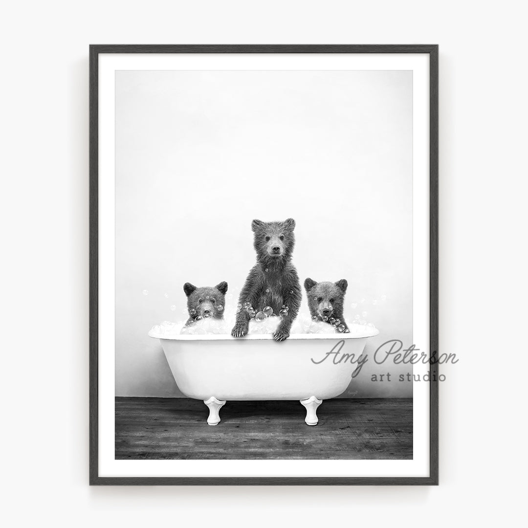 a black and white photo of three dogs in a bathtub