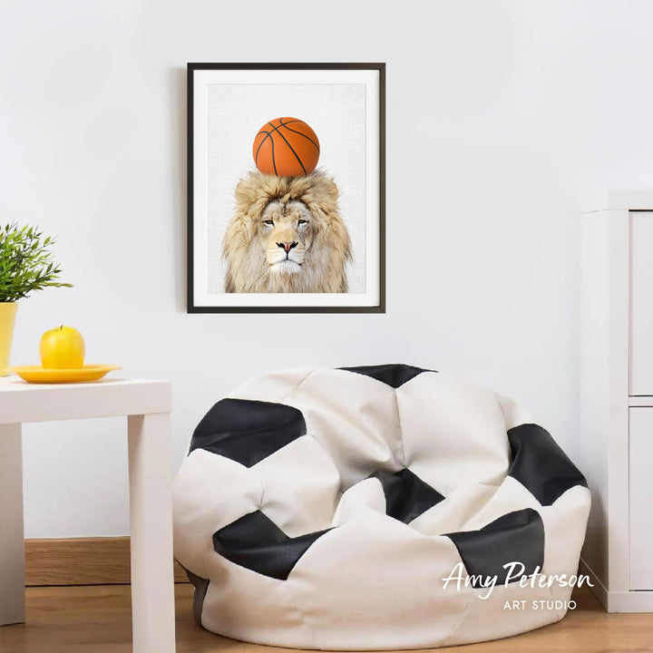 a framed picture of a lion with a basketball on its head, hanging on a wall in a room with a white table and a black and white bean bag chair.