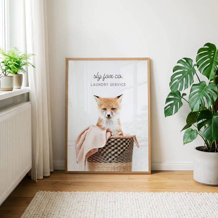 A framed photograph of a cat sitting in a laundry basket, with the text "sky fox co. Laundry service" displayed on the frame.