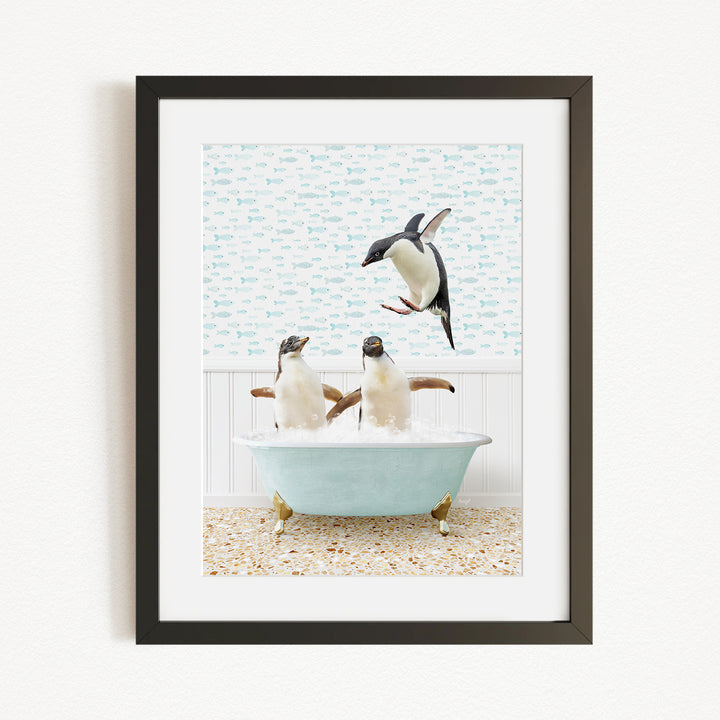 A framed image depicting two penguins sitting in a bathtub, with one penguin flying towards the other.