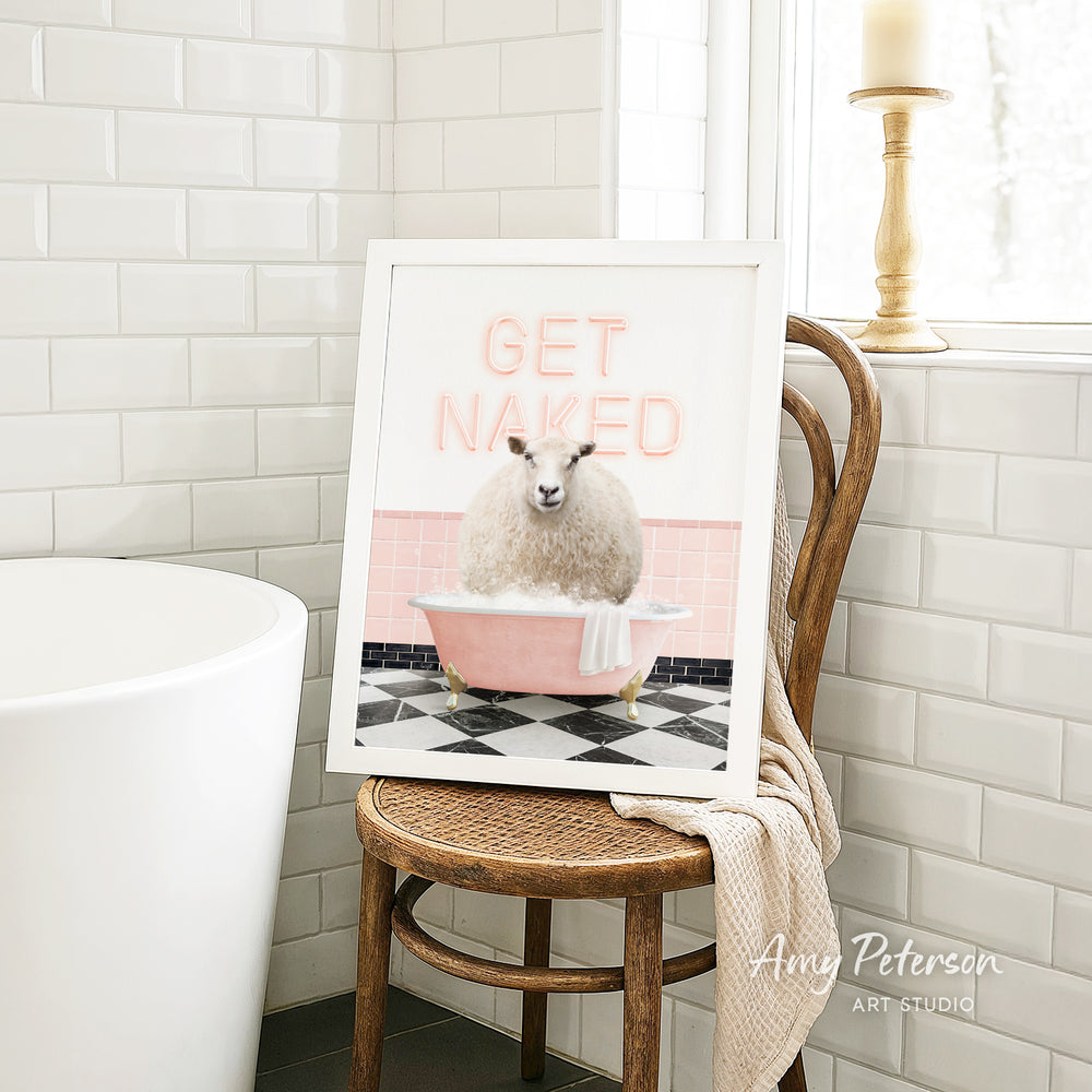A framed image of a sheep sitting in a pink bathtub, with the text "GET NAKED" displayed on the frame.