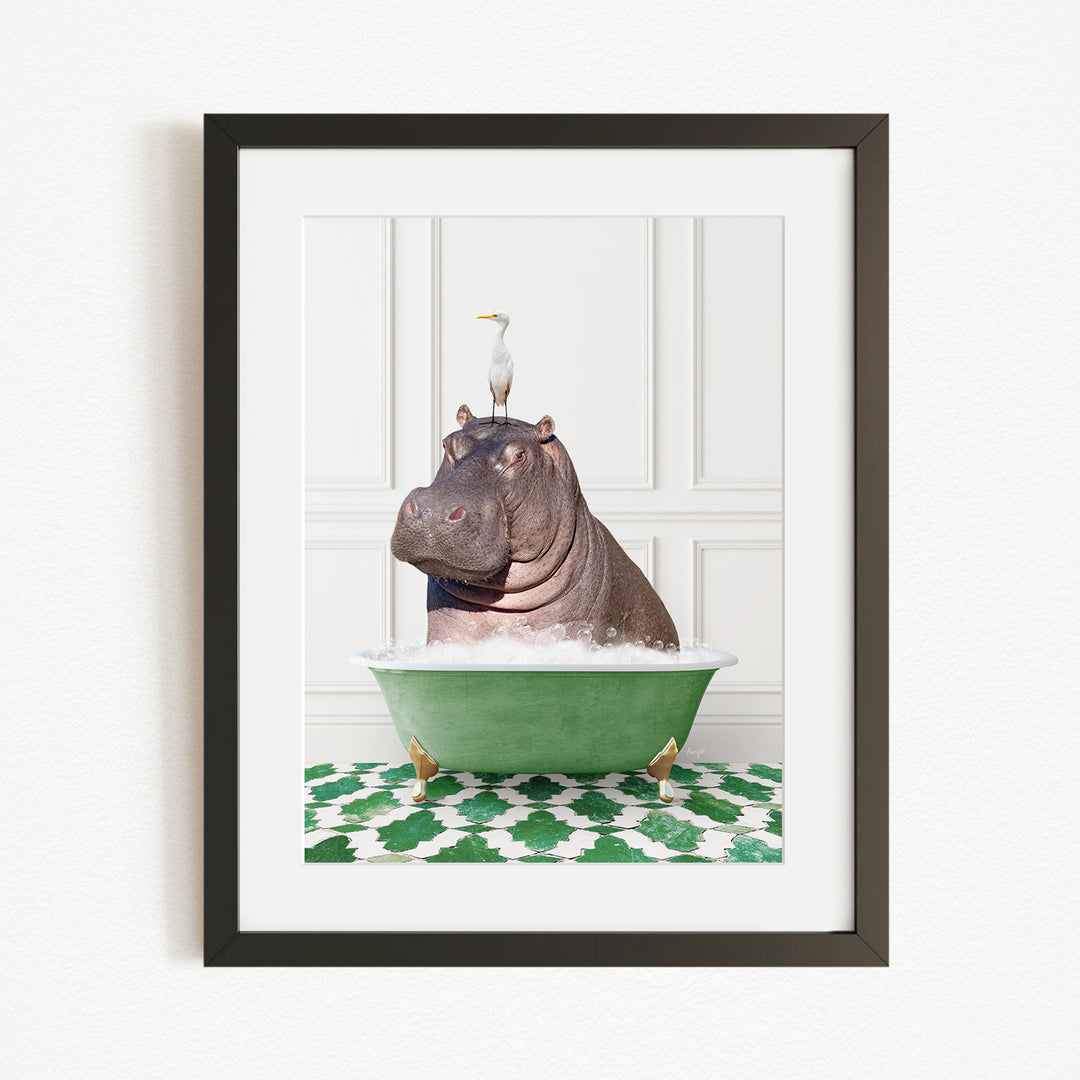 A framed image depicting a hippopotamus sitting in a green bathtub, with a bird perched on its head.