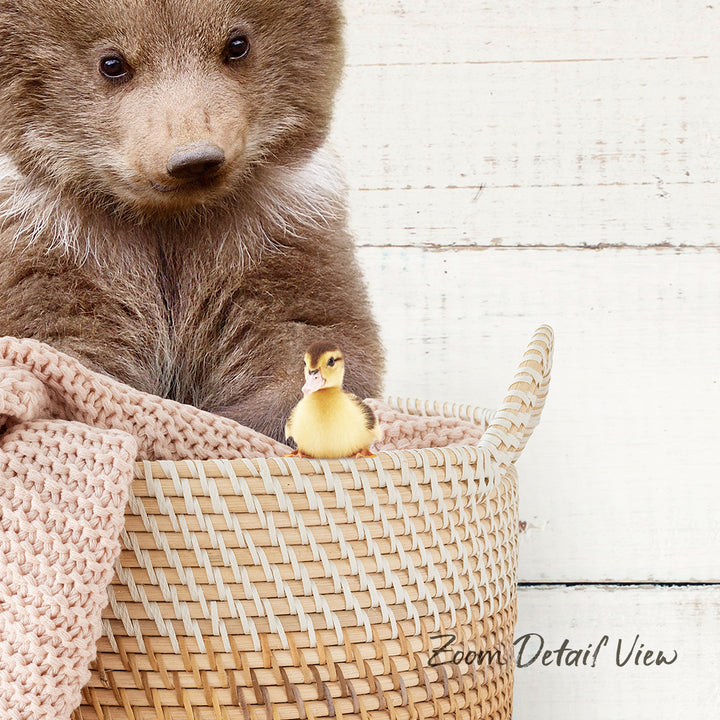 A brown bear sits in a woven basket, with a small yellow duck perched on the edge of the basket.
