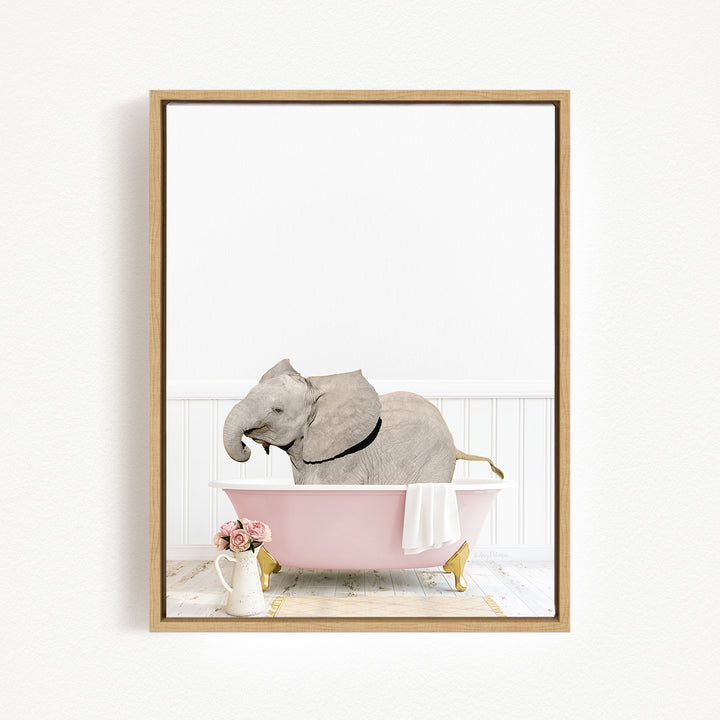 A gray elephant is sitting in a pink bathtub, surrounded by pink flowers and a white vase.