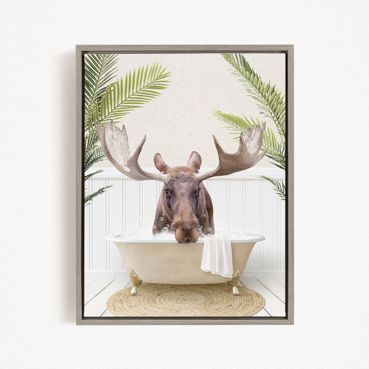 A moose with large antlers is sitting in a bathtub filled with water, surrounded by green plants.