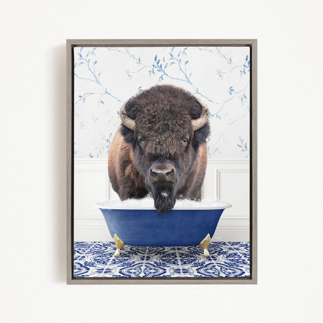 A buffalo is standing in a blue bathtub, with its head submerged in the water, creating a whimsical and humorous scene.