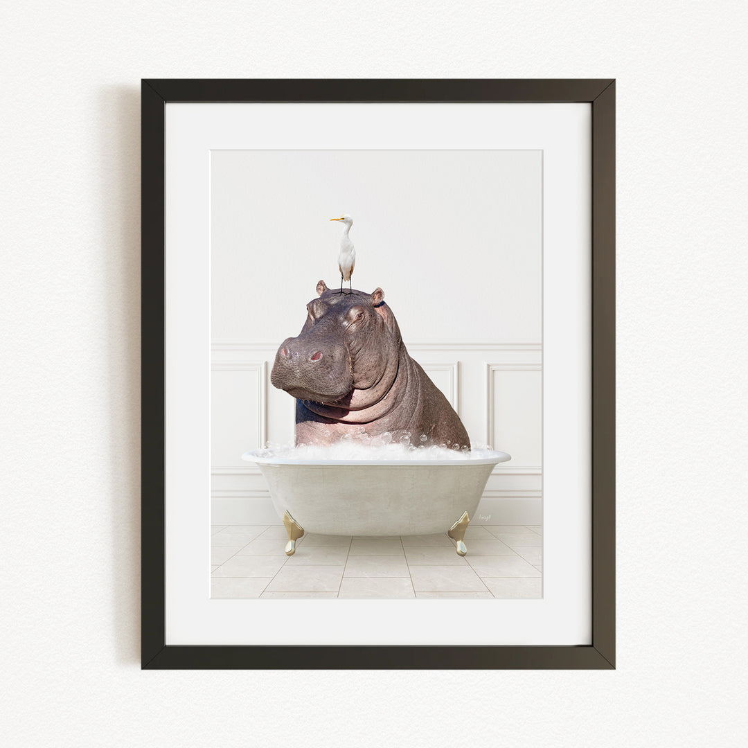 A framed image depicting a large hippopotamus sitting in a bathtub, with a seagull perched on its head.