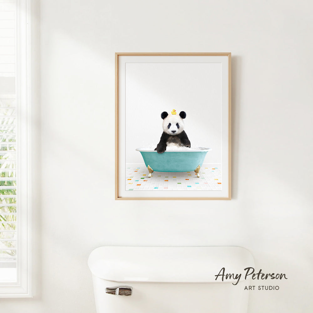 A framed image of a panda sitting in a bathtub, with a white toilet and a window in the background.