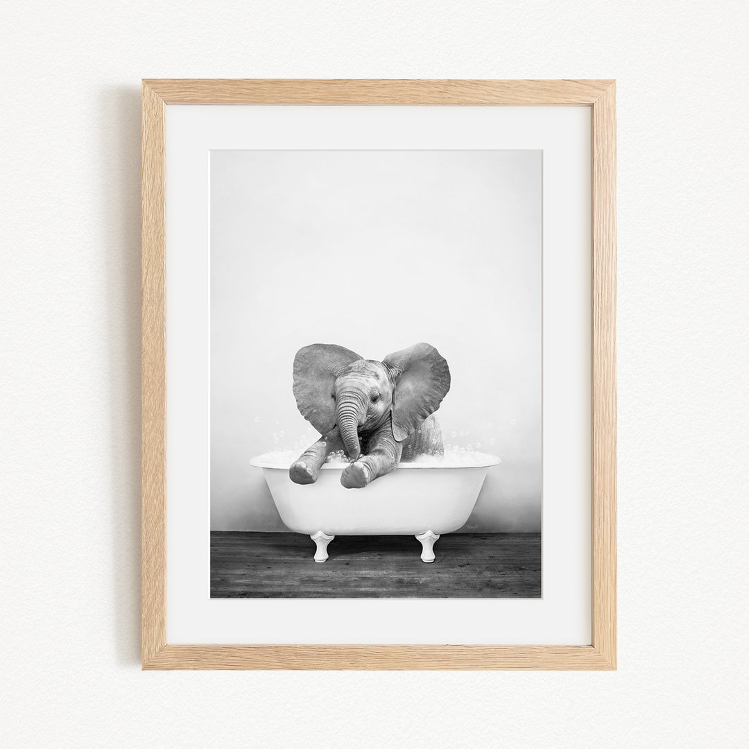A baby elephant sitting in a bathtub, enjoying a bath.