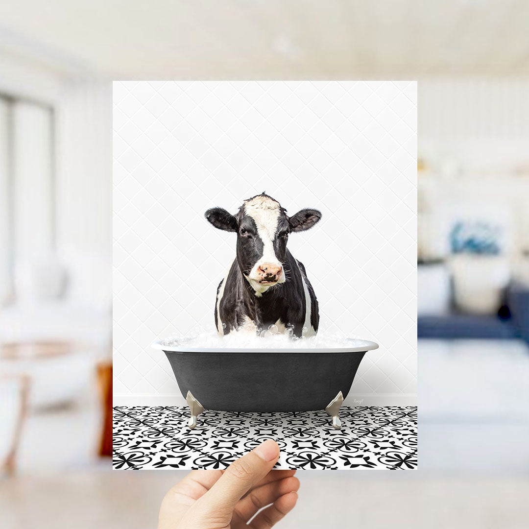 A black and white cow is sitting in a bathtub filled with water, creating a whimsical and humorous scene.