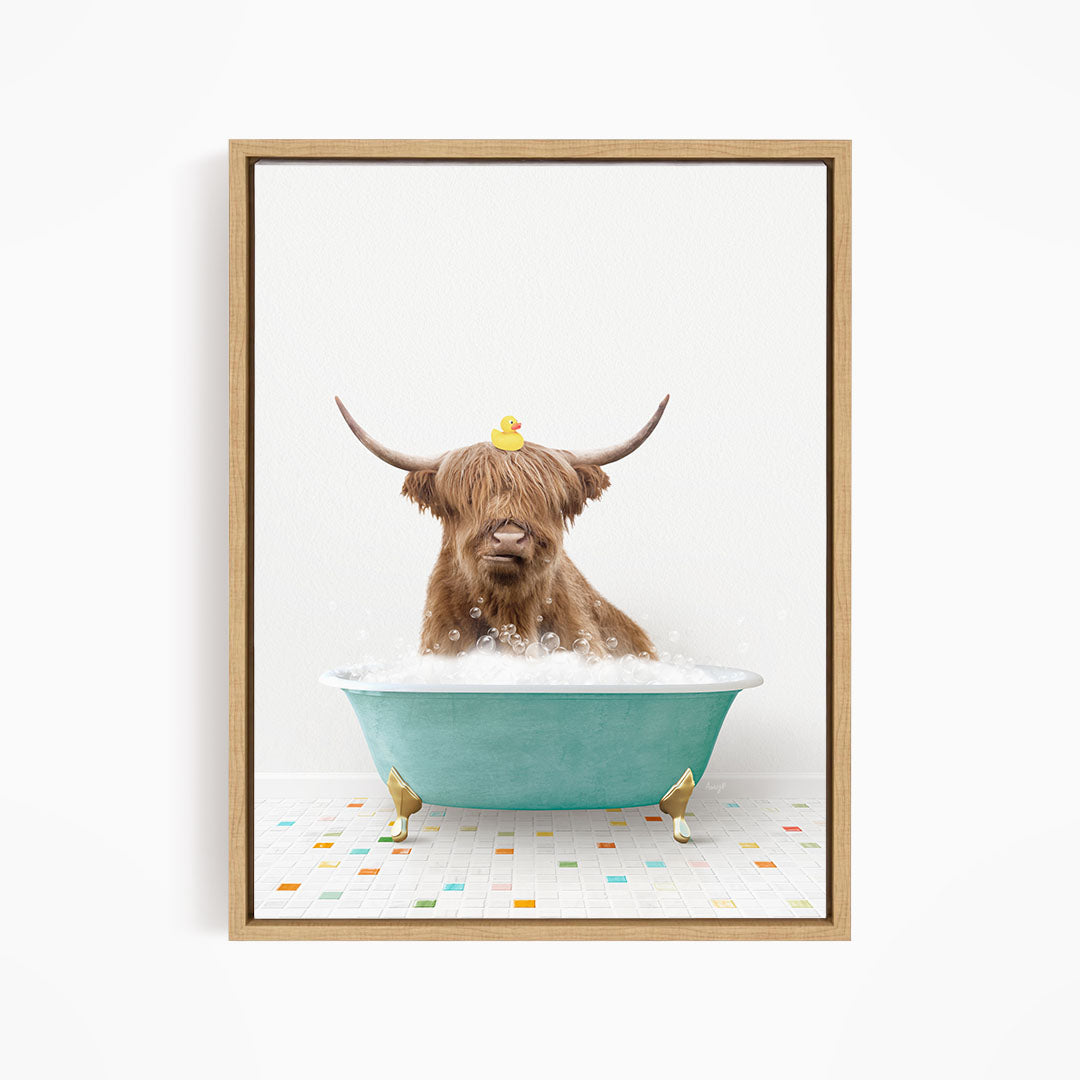 A brown cow with long horns is sitting in a blue bathtub filled with bubbles, with a yellow rubber duck perched on its head.