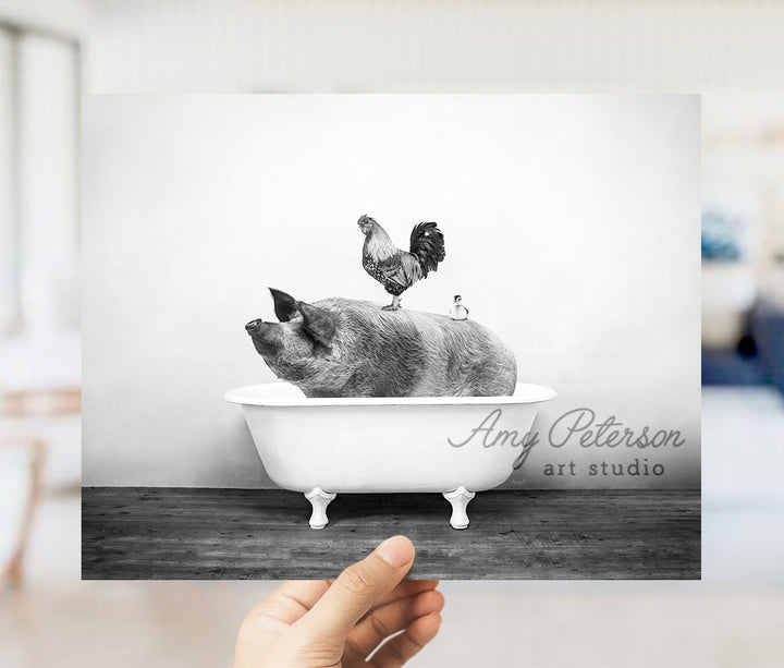 a person holding up a picture of a pig in a bathtub