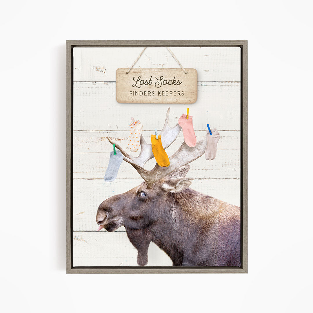 A moose with a sign that says "Last Socks Finders Keepers" hanging above it.