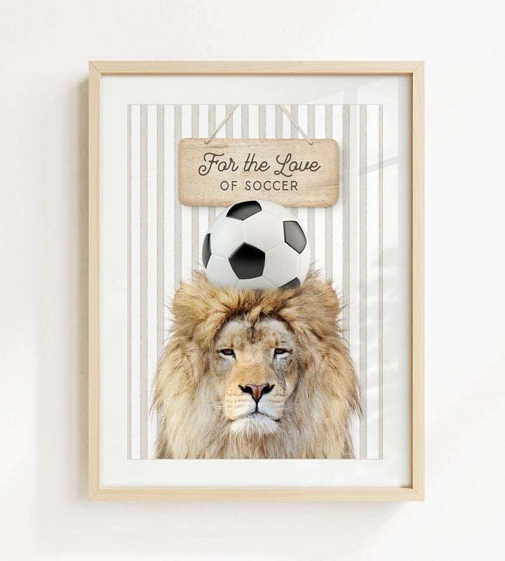 A framed image of a lion with a soccer ball on its head, accompanied by a wooden sign that says "For the Love of Soccer".