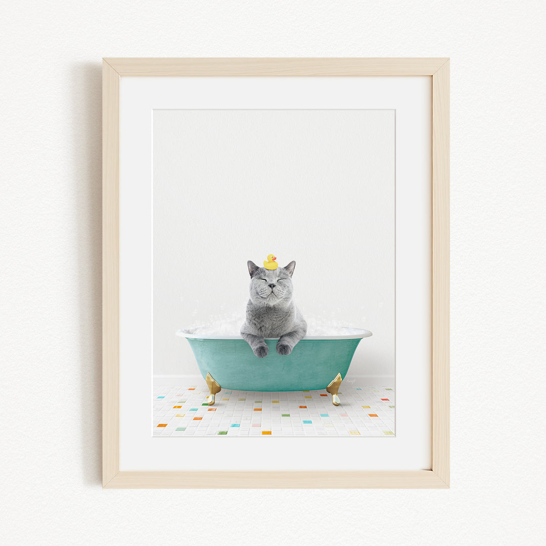 A gray cat sitting in a green bathtub, with two gold-colored birds perched on the sides of the tub.