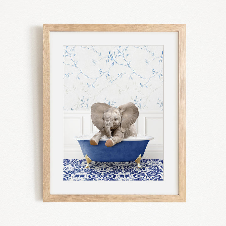 A baby elephant sitting in a blue bathtub, surrounded by a blue and white patterned rug and a white wall with blue floral wallpaper.