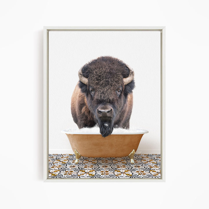 A bison with large horns is standing in a bathtub filled with water, creating a humorous and unexpected scene.