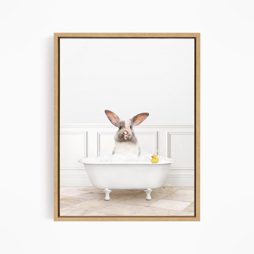 A white rabbit sitting in a white bathtub filled with bubbles, with a rubber duck floating in the water.