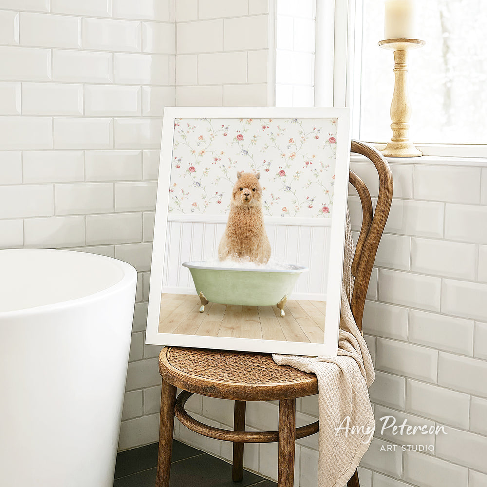 A framed image of a brown dog sitting in a green bathtub, surrounded by a floral pattern, is displayed on a wooden chair in a bathroom setting.