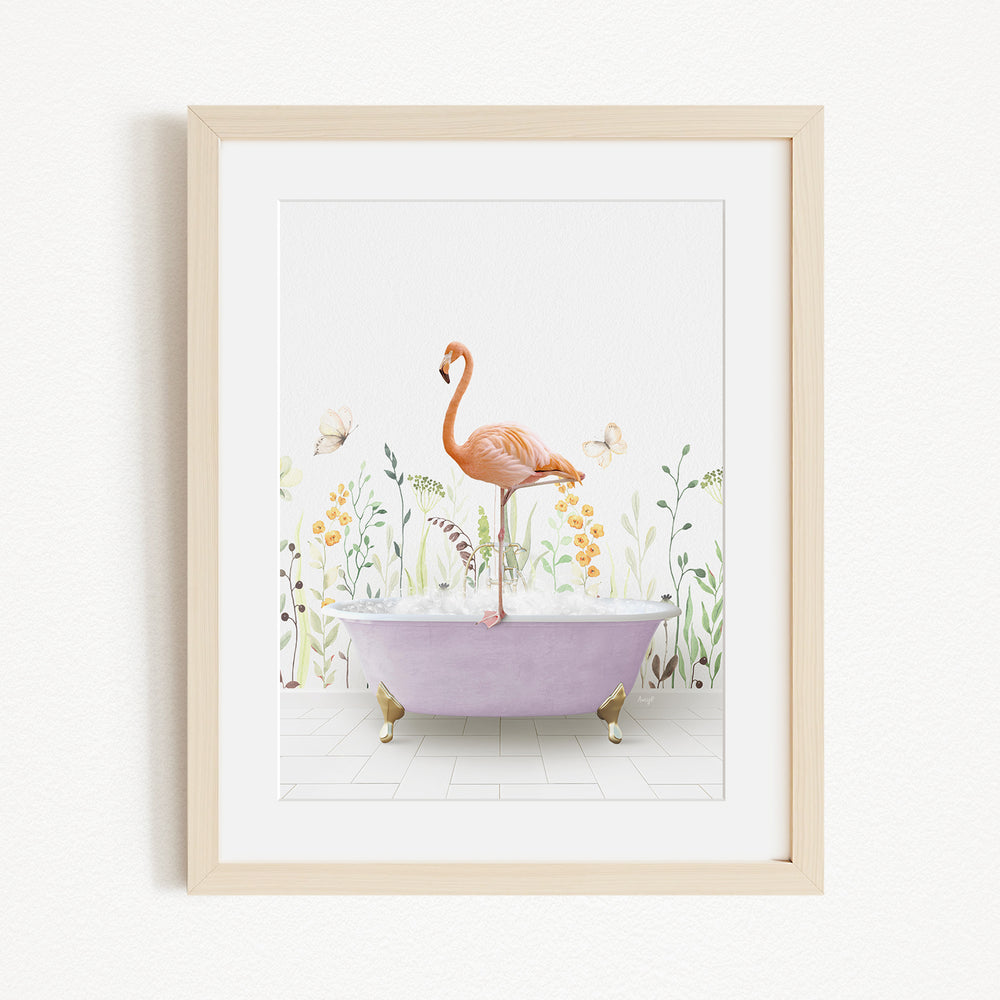 A framed illustration depicting a pink flamingo standing on a purple bathtub filled with bubbles, surrounded by a garden scene with flowers and butterflies.