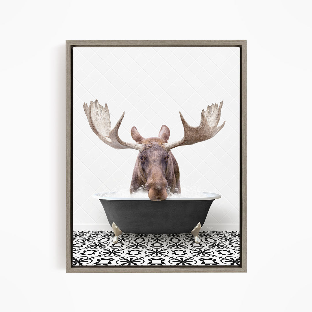 A moose with large antlers is sitting in a bathtub filled with water, creating a whimsical and playful scene.