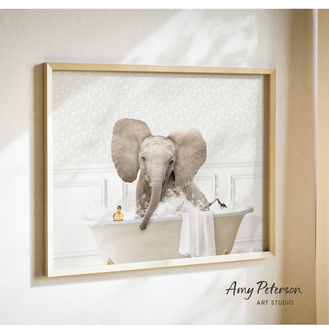A framed photograph of an elephant sitting in a bathtub filled with water and bubbles, with a person's face visible in the background.