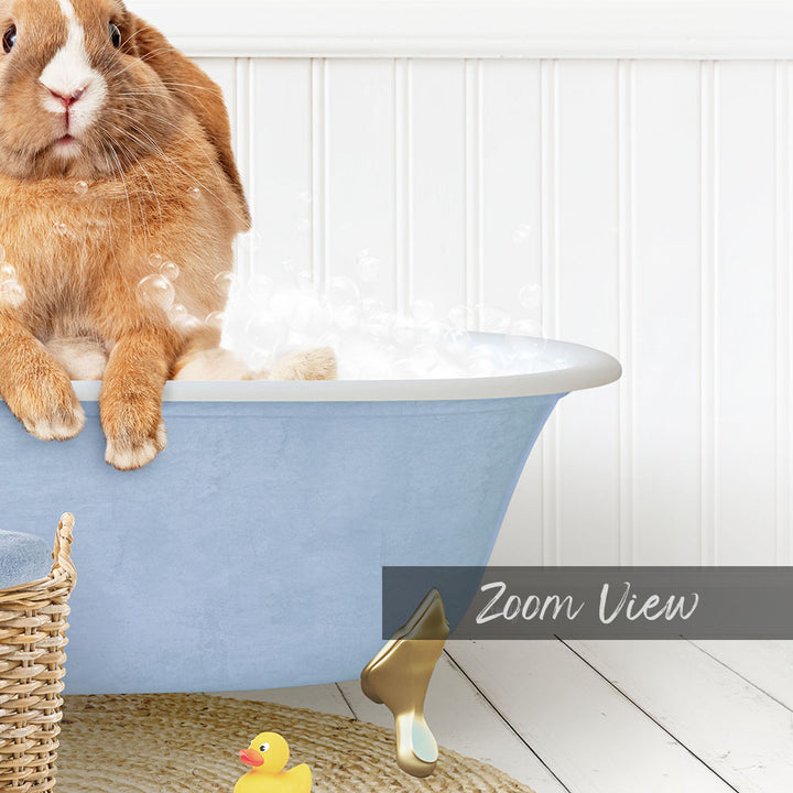 A brown rabbit sitting in a blue bathtub filled with bubbles, with a yellow rubber duck nearby.
