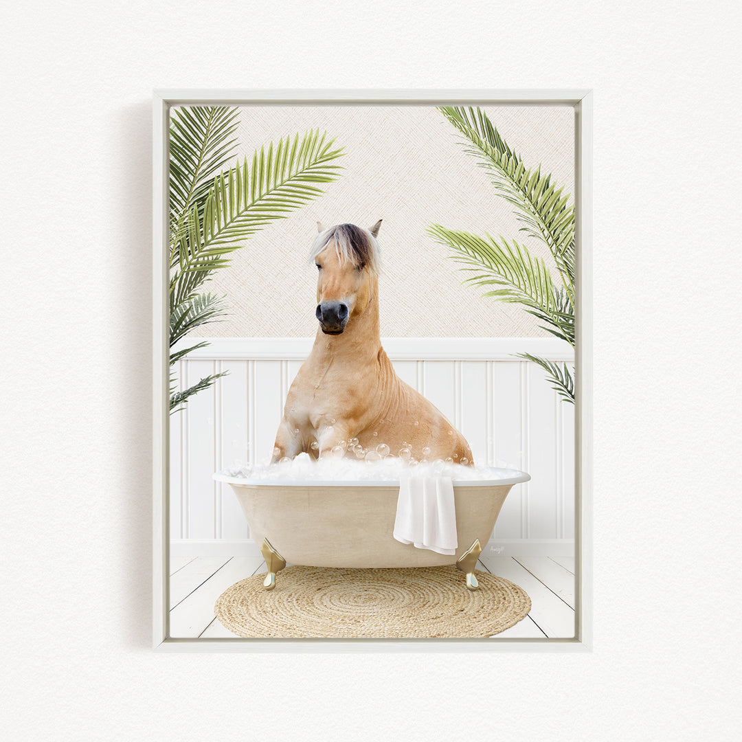 A light brown horse is sitting in a white bathtub filled with bubbles, surrounded by green palm leaves and a woven rug on the floor.