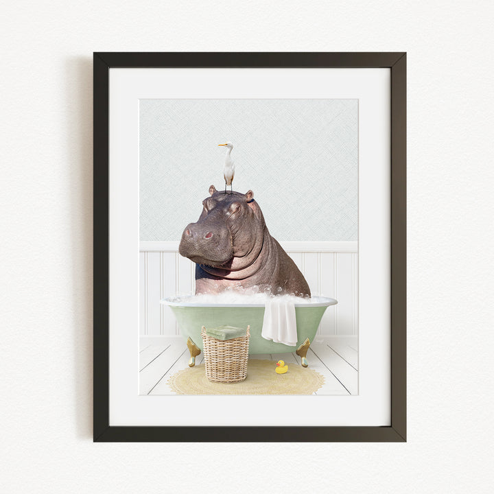 A framed image depicting a hippopotamus sitting in a bathtub, with a bird perched on its head.