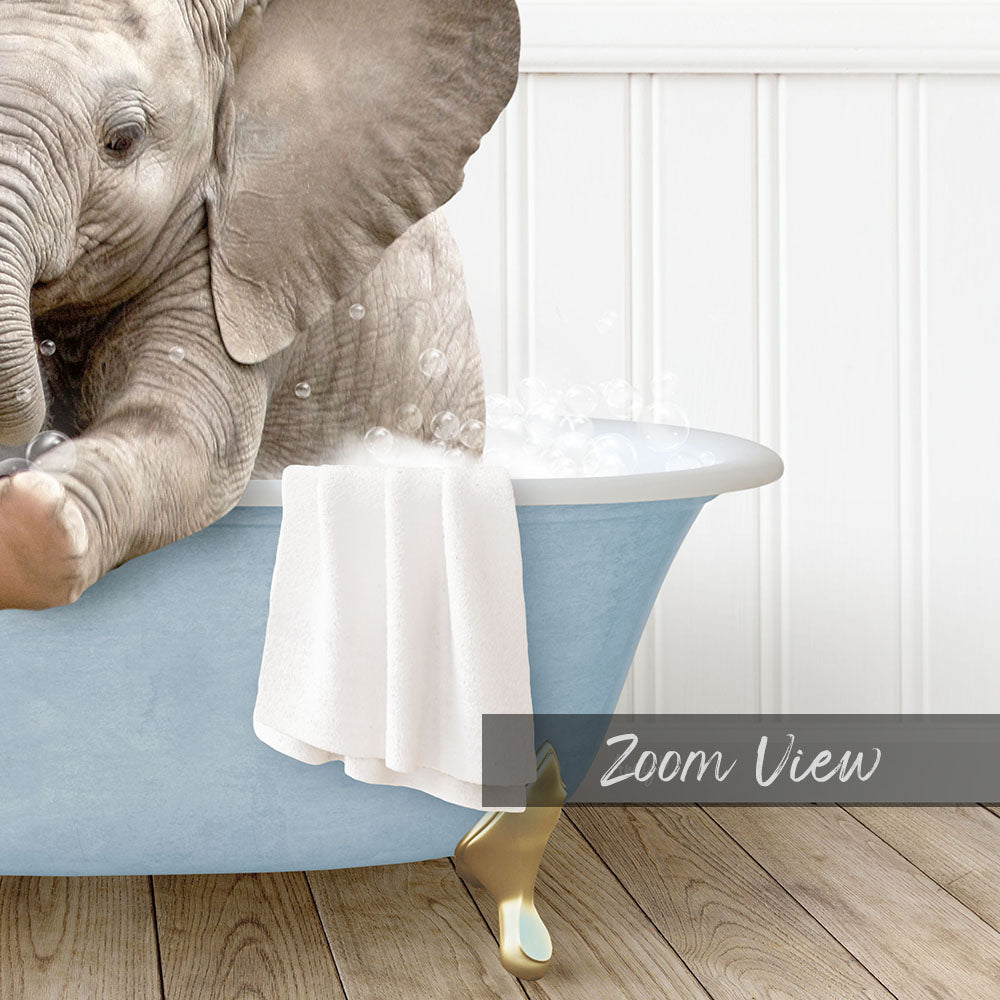 A baby elephant sitting in a blue bathtub, with a towel draped over the side of the tub.