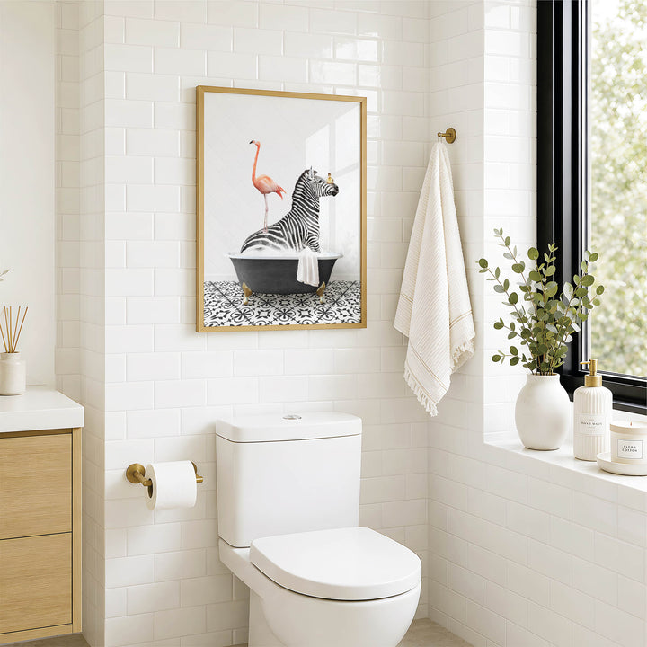 a bathroom with a white toilet, a framed picture of a zebra sitting in a bathtub, and a towel hanging on the wall.