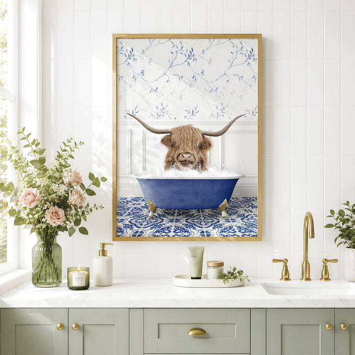 a framed picture of a Highland cow sitting in a blue bathtub, surrounded by flowers and a white and blue floral pattern on the wall.