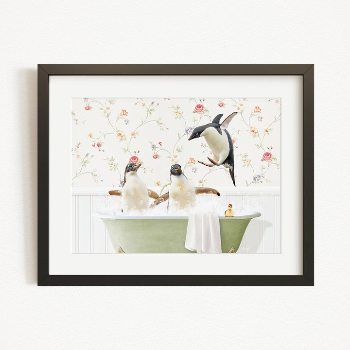 A framed image depicting three penguins sitting in a green bathtub, with one penguin standing on the edge of the tub and another sitting on the side.