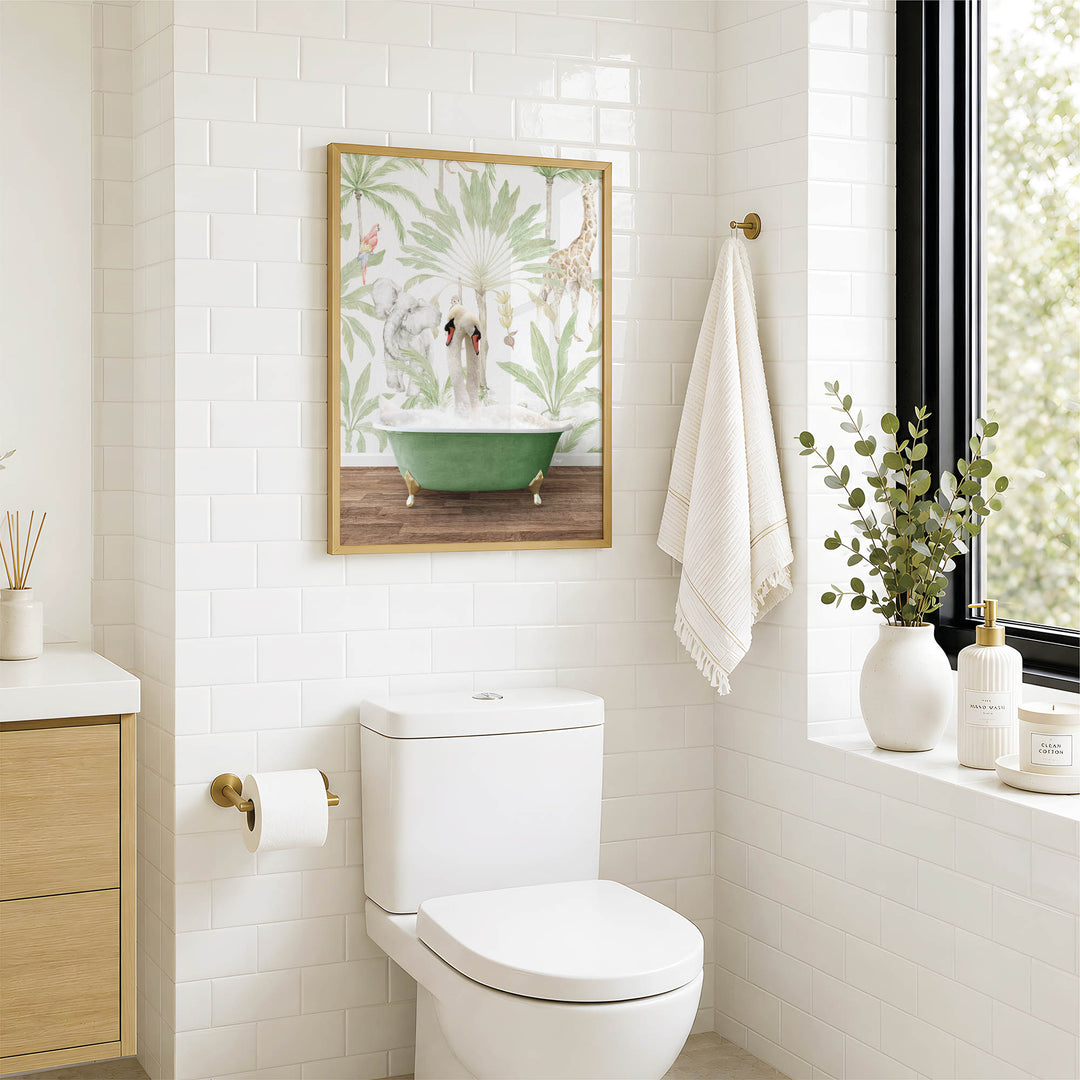 A modern bathroom with a white toilet, a framed picture of a bathtub, and a window with greenery on the sill.