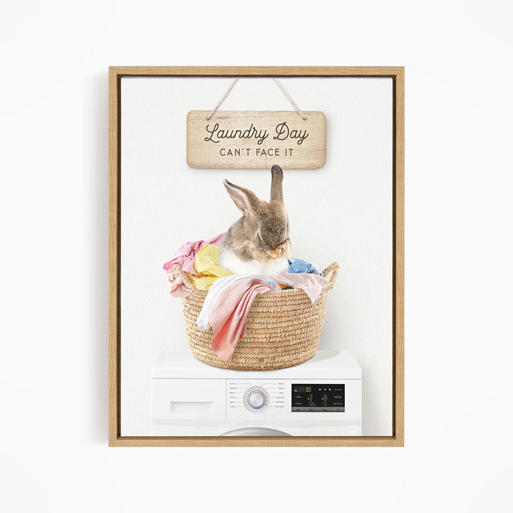 A cute rabbit sitting in a woven laundry basket, with a sign above that says "Laundry Day Can't Face It".