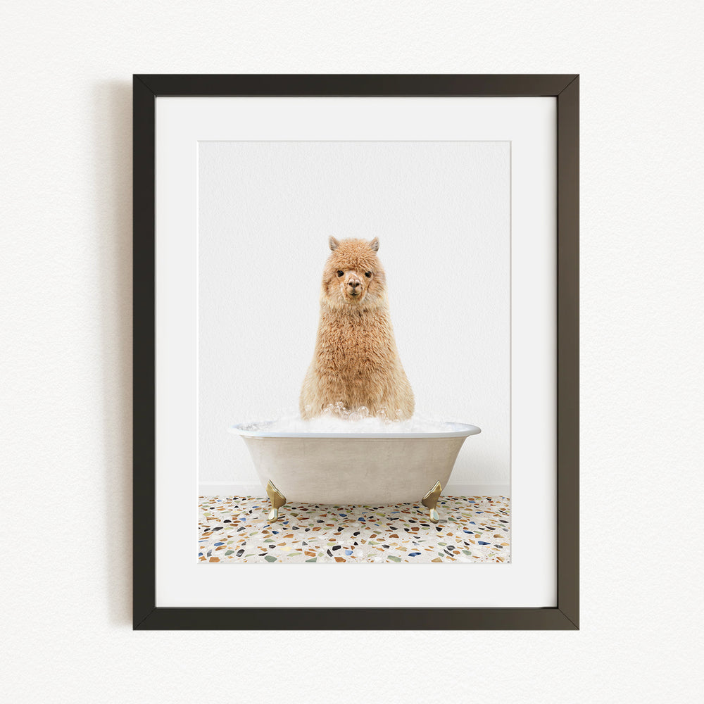 A fluffy brown dog sitting in a white bathtub filled with bubbles, with a speckled tile floor in the background.