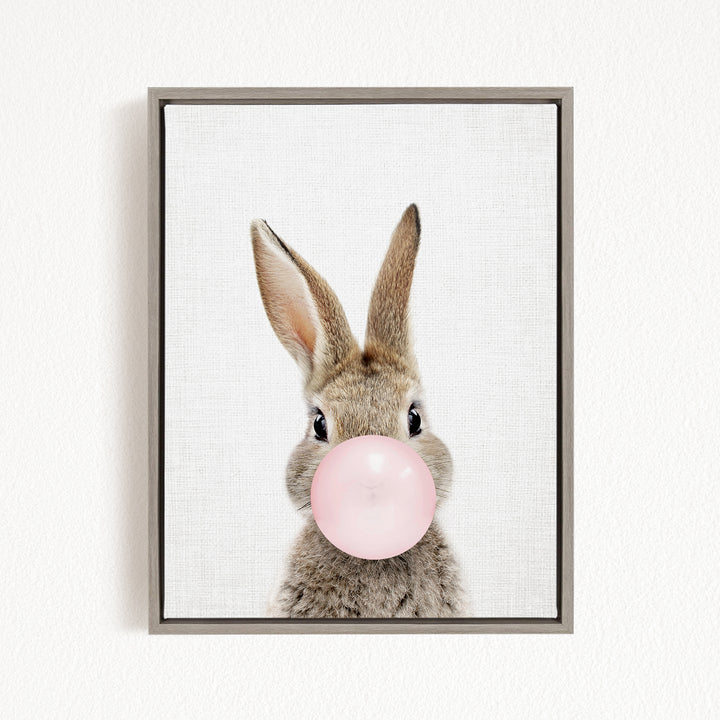 A cute rabbit is blowing a pink bubble with its nose, creating a playful and whimsical scene.