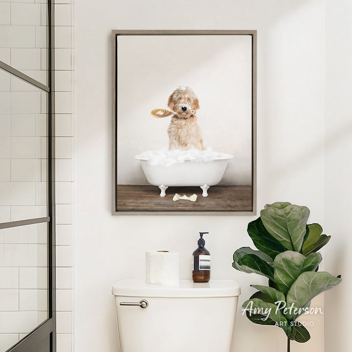 A framed image of a dog sitting in a bathtub, holding a toy, is displayed on the wall above a white toilet in a bathroom.