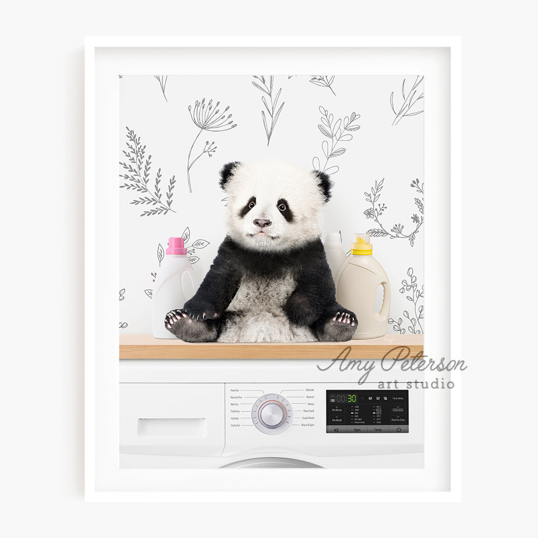 a panda bear sitting on top of a washing machine